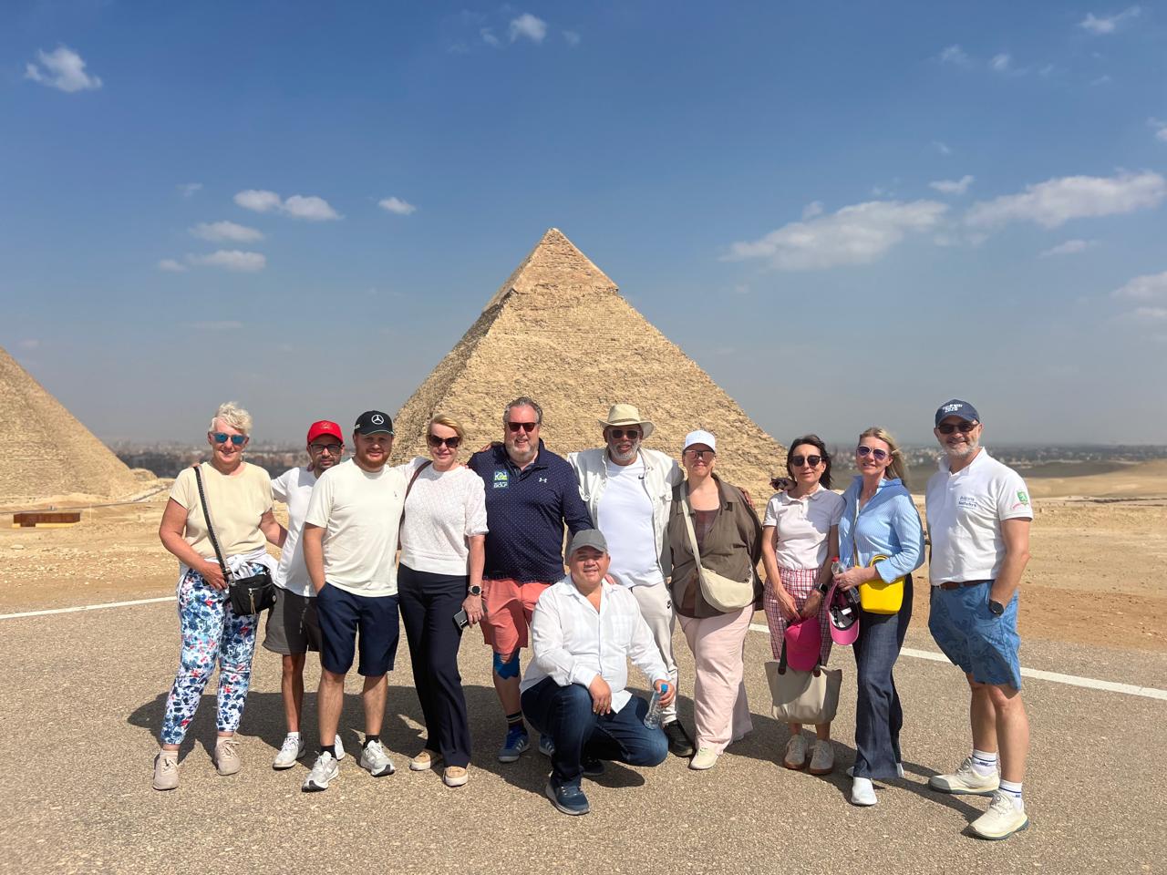 Golf group in front of the Pyramids of Giza with the Grand Egyptian Museum beyond